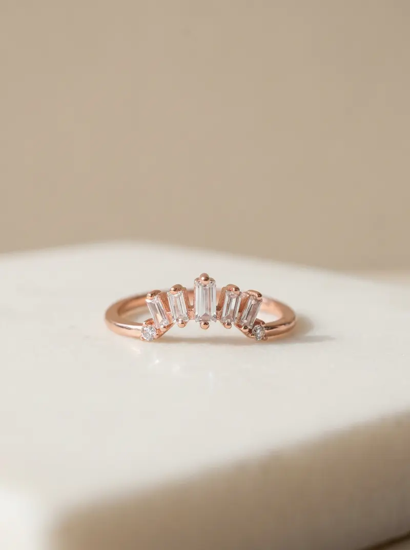Baguette crown ring lying flat on an ivory slab