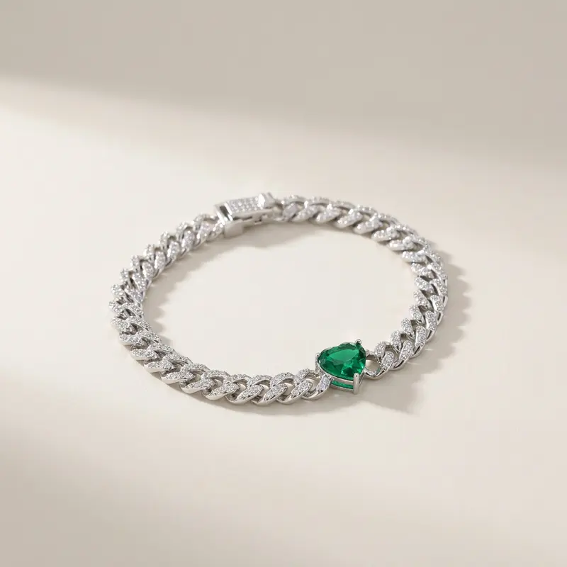 Emerald heart pavé curb bracelet on an off-white surface