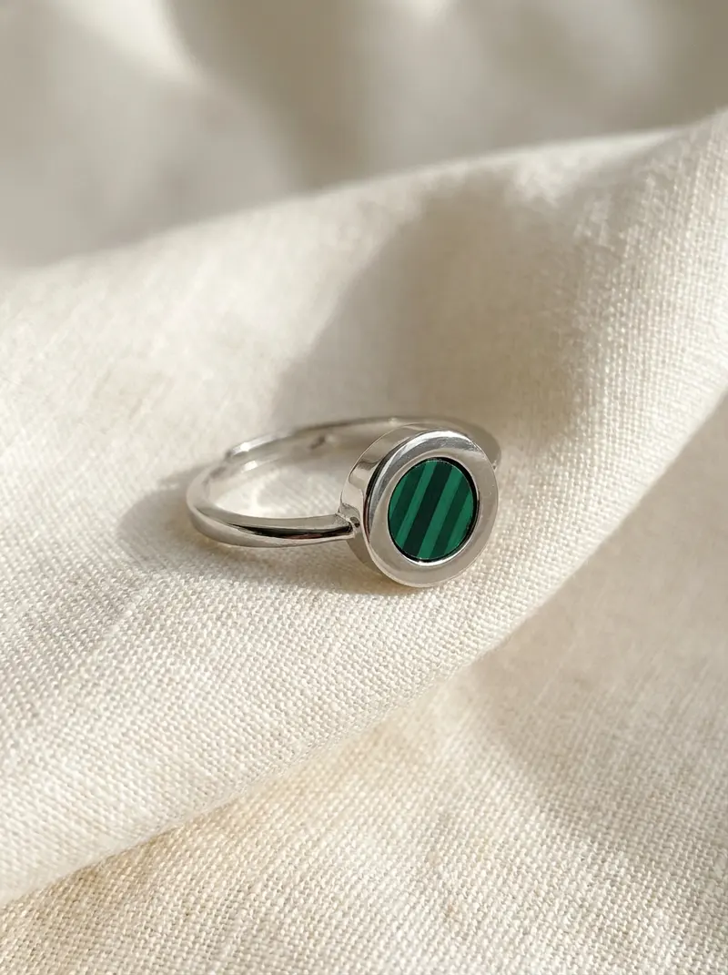 Close-up of the malachite round ring on folded linen