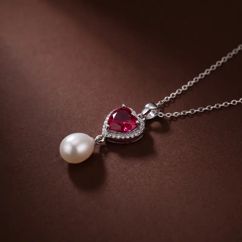 Close-up of the ruby-red heart and pearl pendant on cocoa